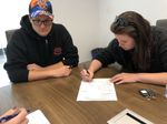 Tayler and Brent signing the house sales contract