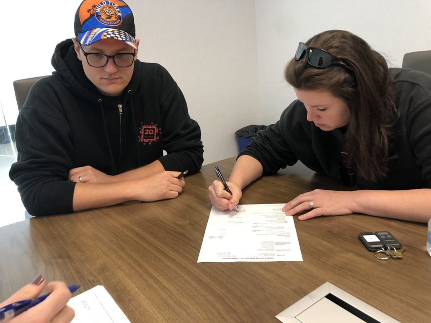 Tayler and Brent signing the house sales contract
