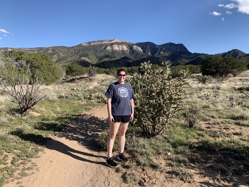 Tayler standing on a rocky trail in the Sandia Mountains