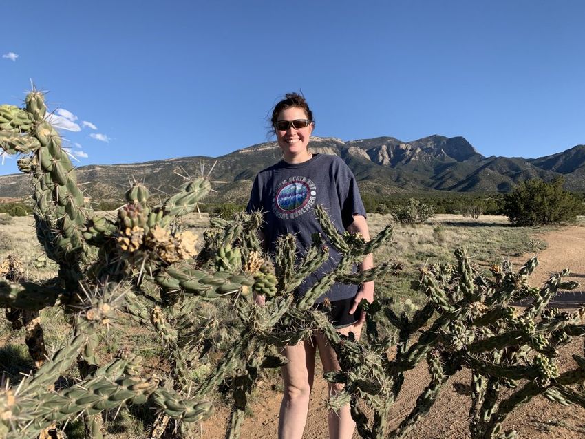 Tayler stands behind some cactus on the trail
