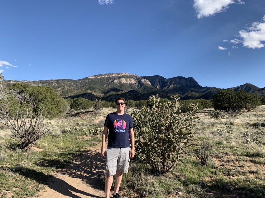 Brent standing on a rocky trail in the Sandia Mountains
